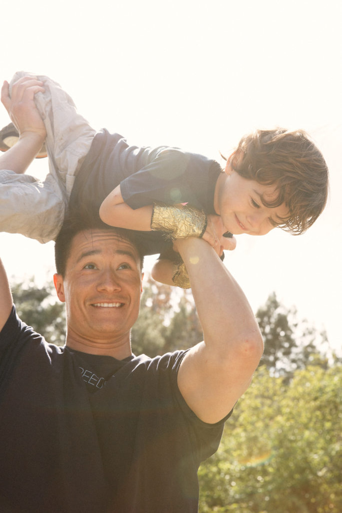 Photo of father lifting his son in the air