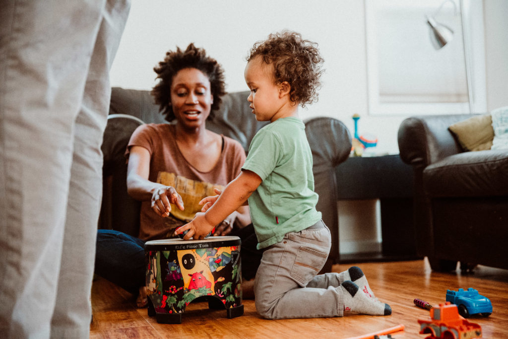 a little boy and his mom play with a drum on the floor - Highland Park, Los Angeles, CA