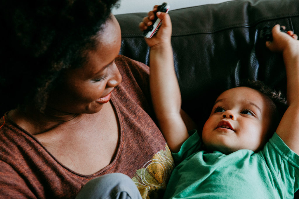 Mom holding toddler and snuggling on couch