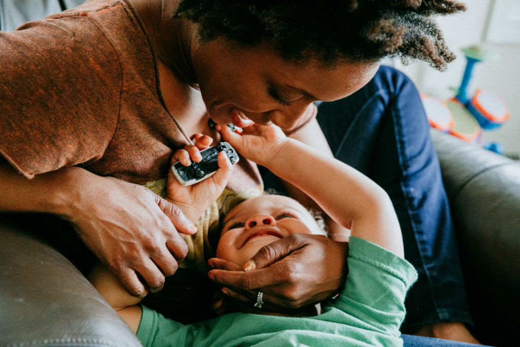 Mom and toddler snuggling and playing with cars