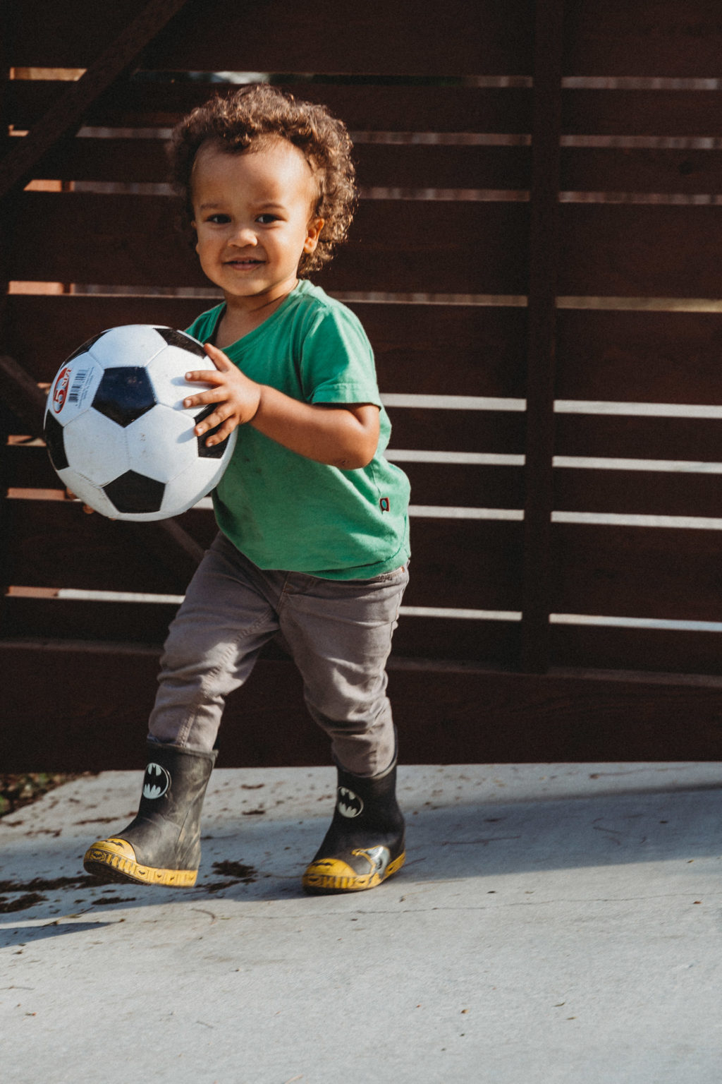 Toddler playing outside with soccer ball