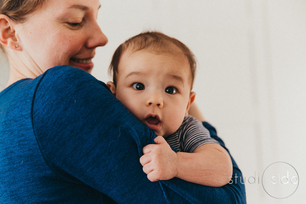 Baby in mom's arms looking at the camera, Los Angeles, CA