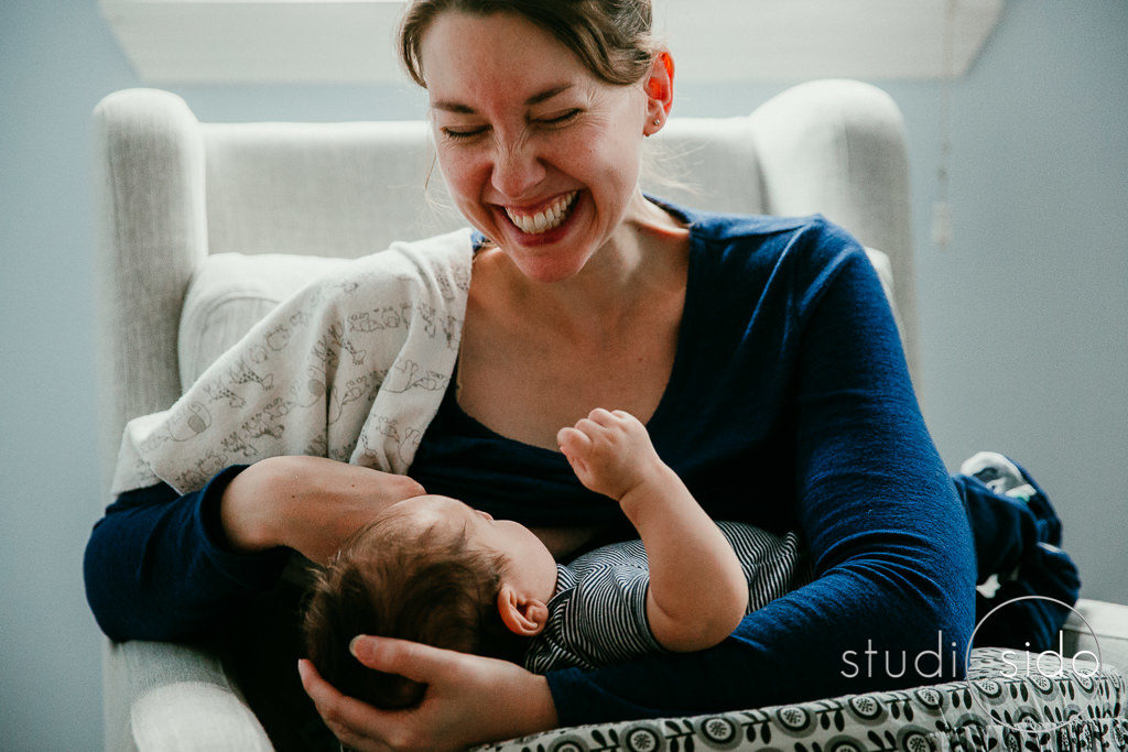 Mama laughing while nursing her baby, Los Angeles, CA