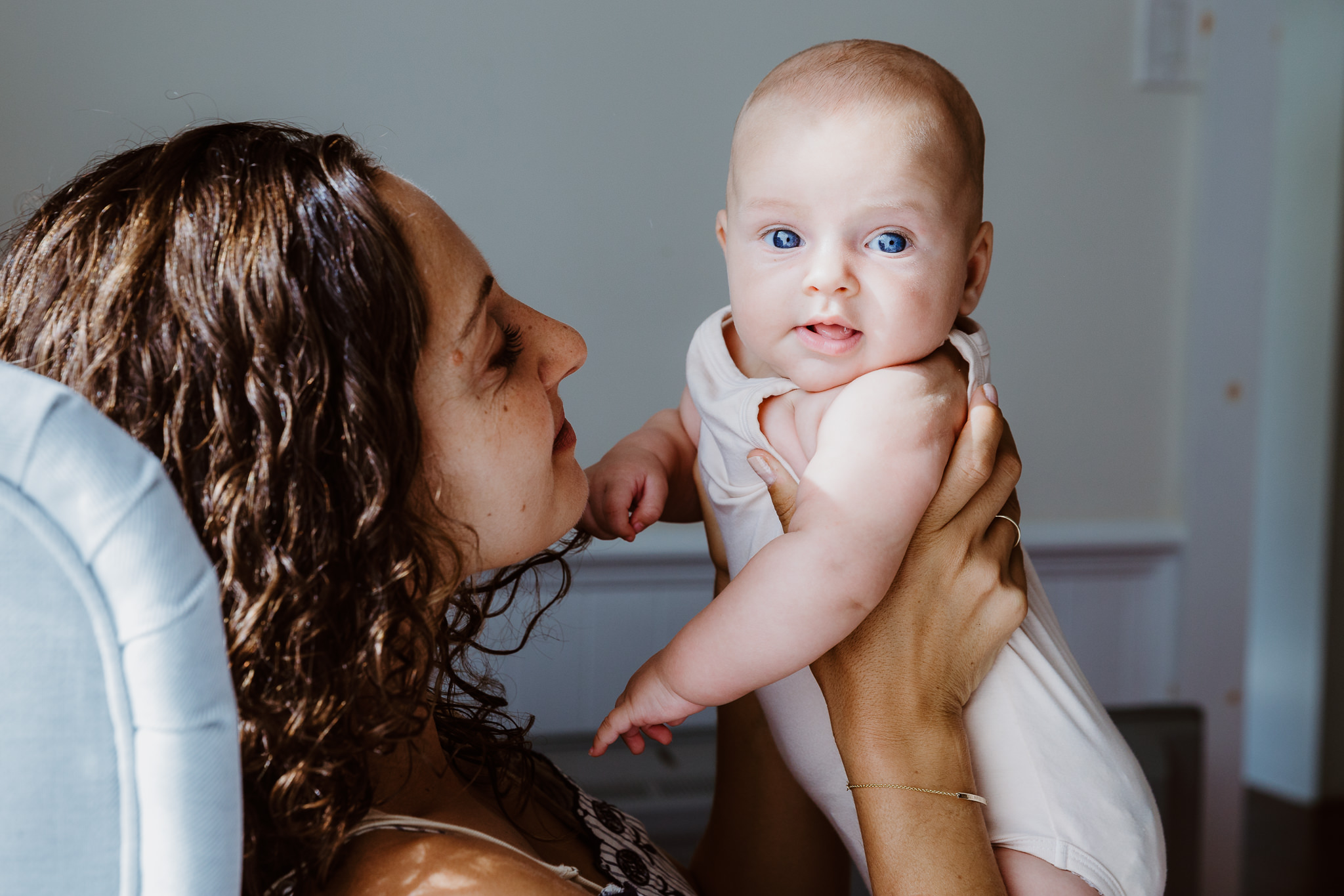 mom holds baby who looks at camera with bright blue eyes - Atwater Village, CA