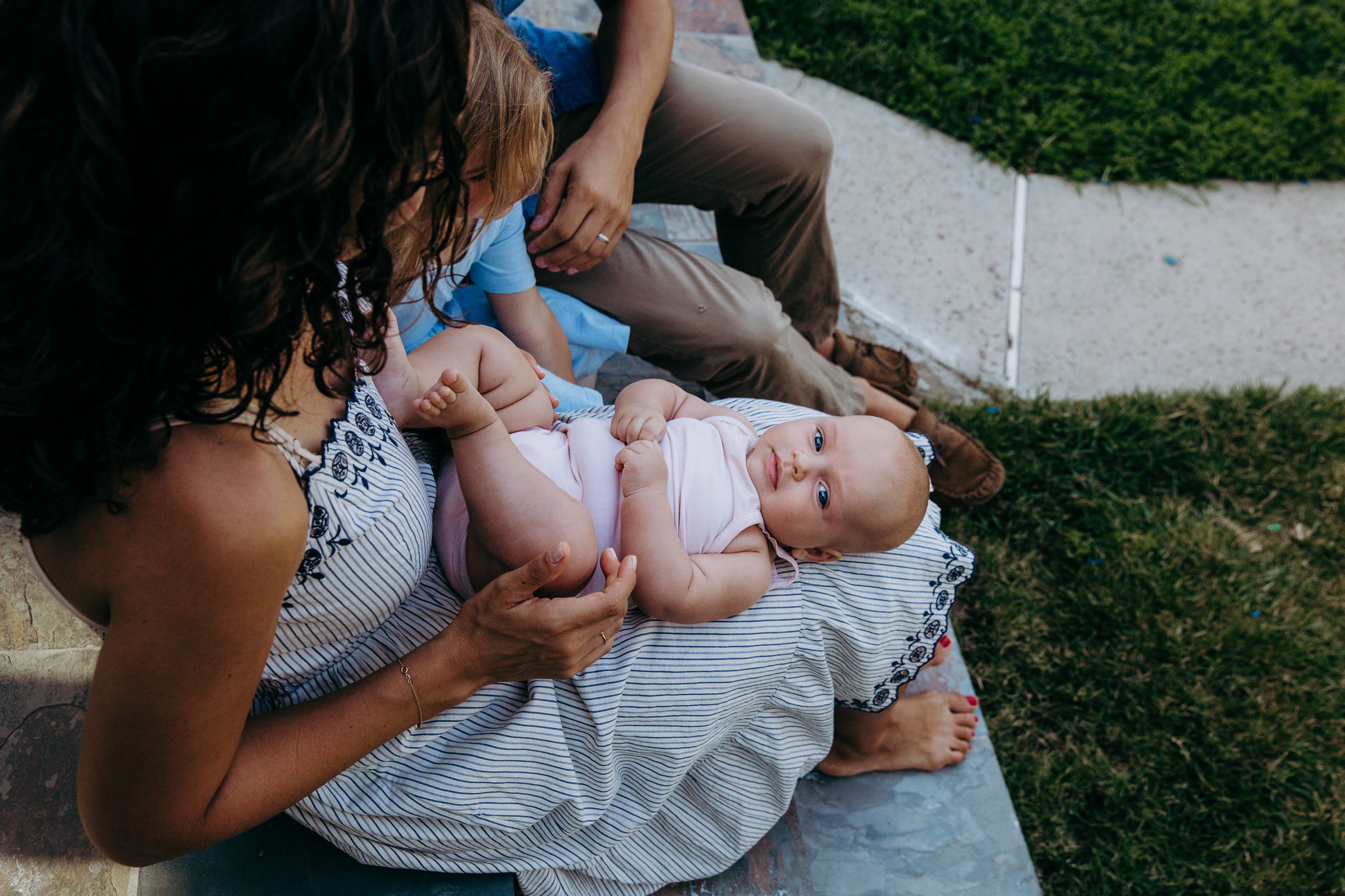 baby lies in her mom's lap and looks at camera - Atwater Village, CA