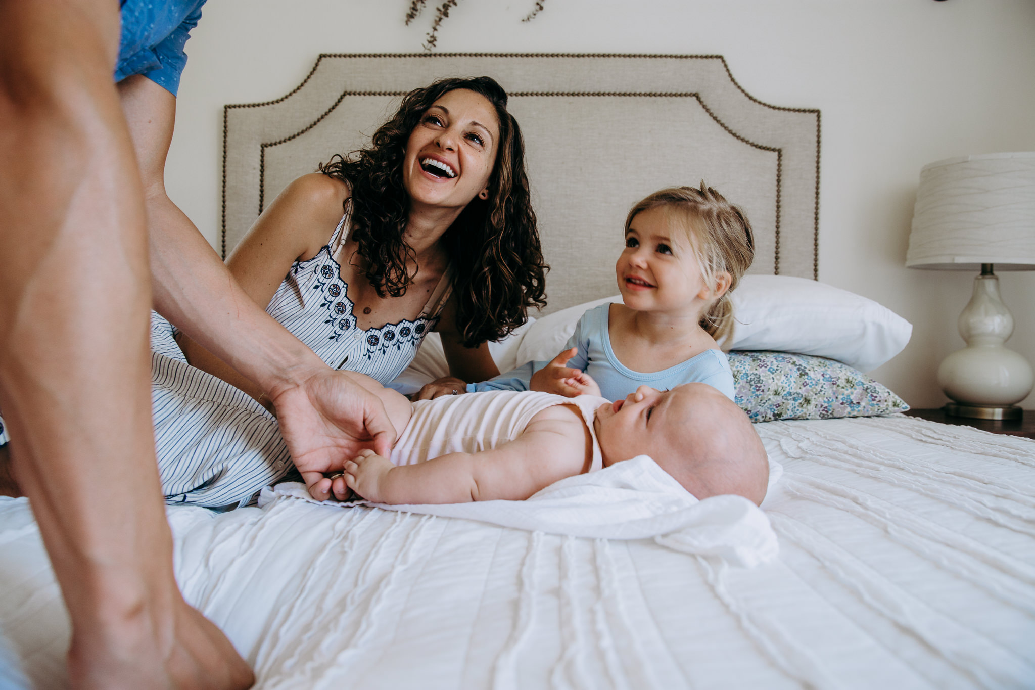 mom and her daughters on a bed with daddy leaning over - Atwater Village, CA