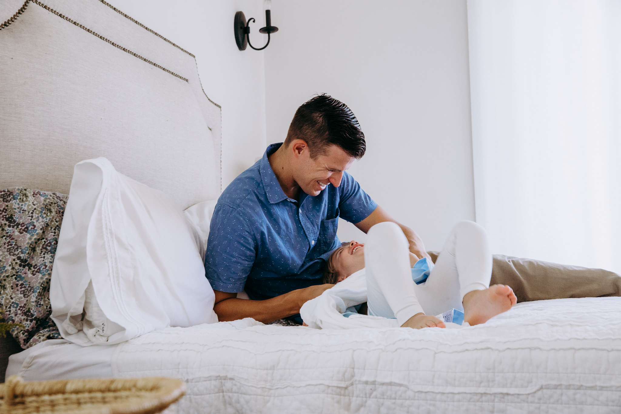 dad plays with toddler daughter on bed - Atwater Village, CA