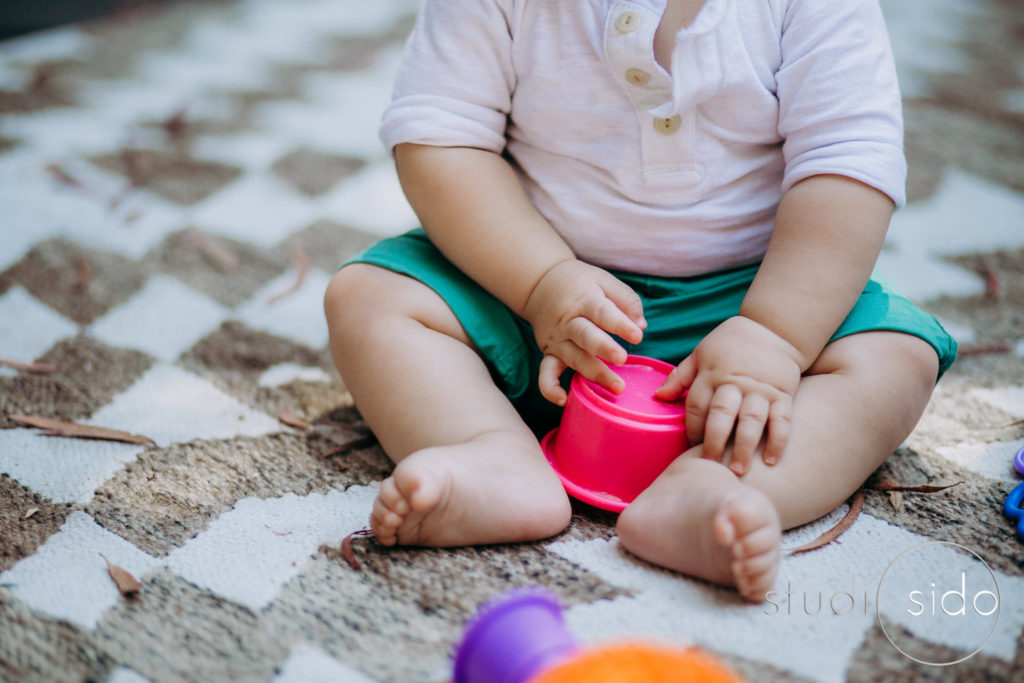 Baby toes and fingers - little boy plays with cup toys