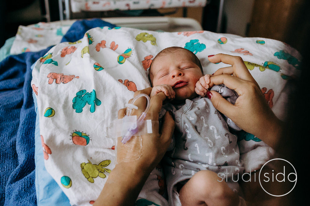 Newborn holds mama's fingers