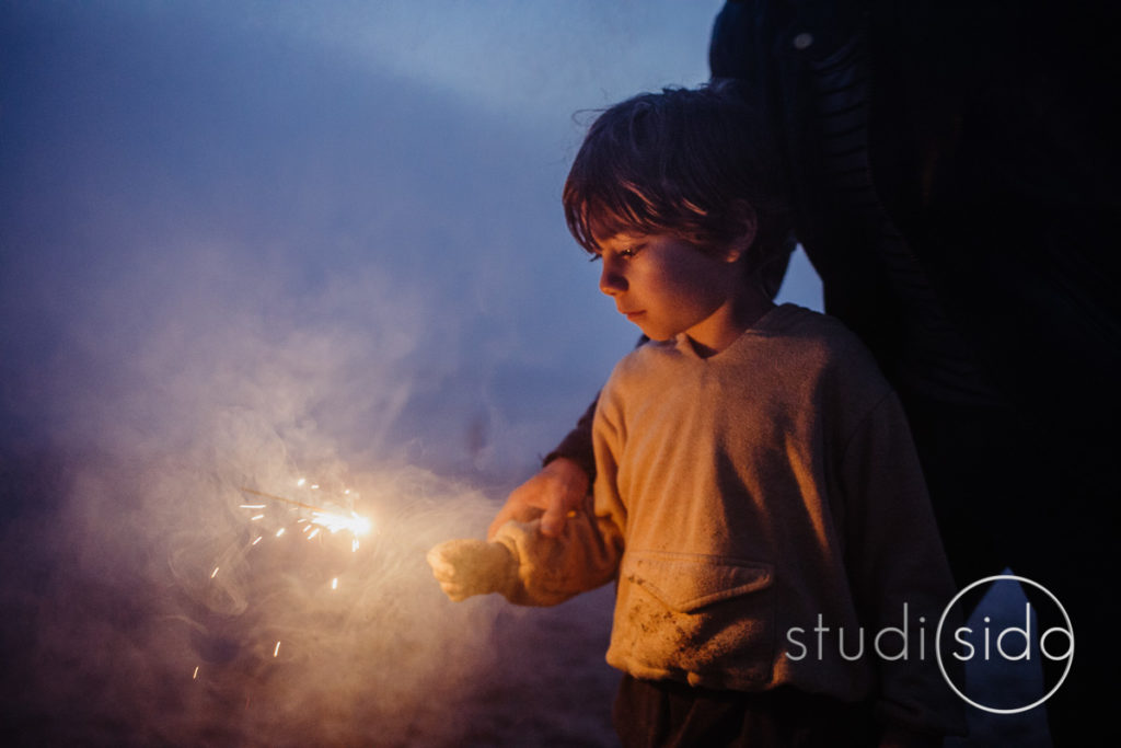 A boy with a sparkler on the beach in Santa Monica, California.