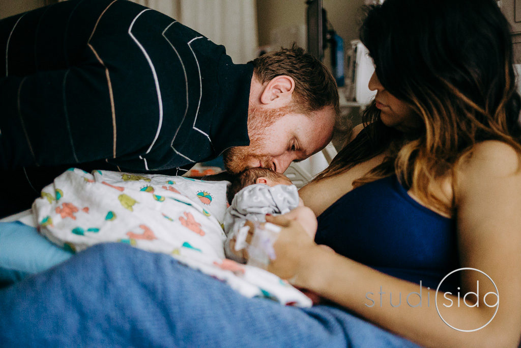 Dad kisses newborn on the head