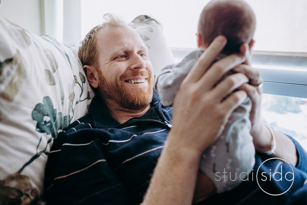 Dad smiles at newborn son