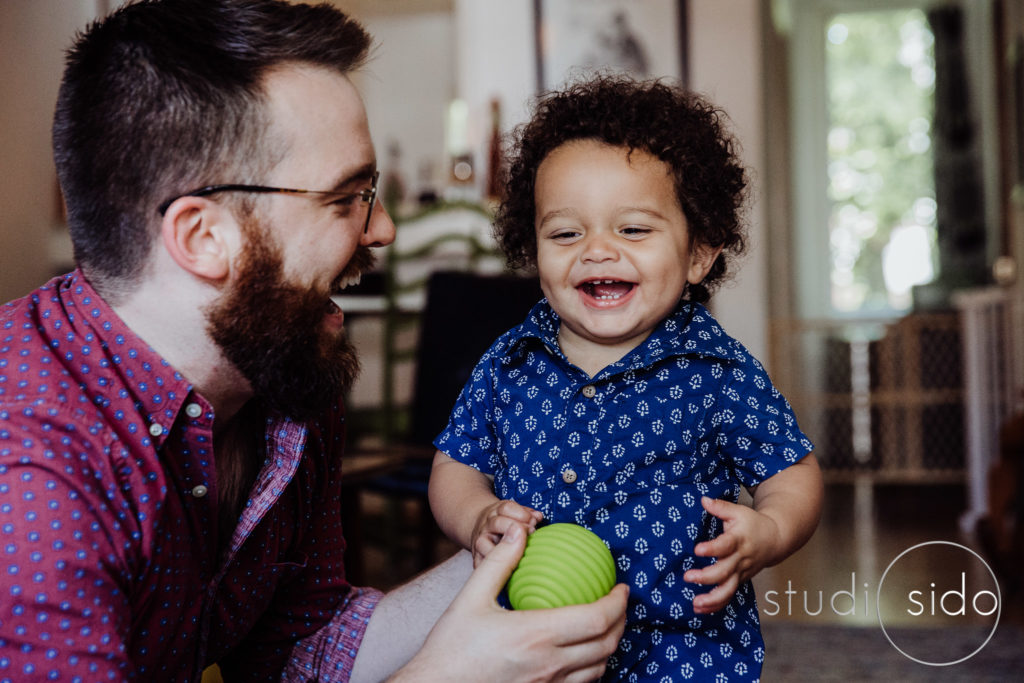 A dad and little boy laugh together in West Hollywood, CA.