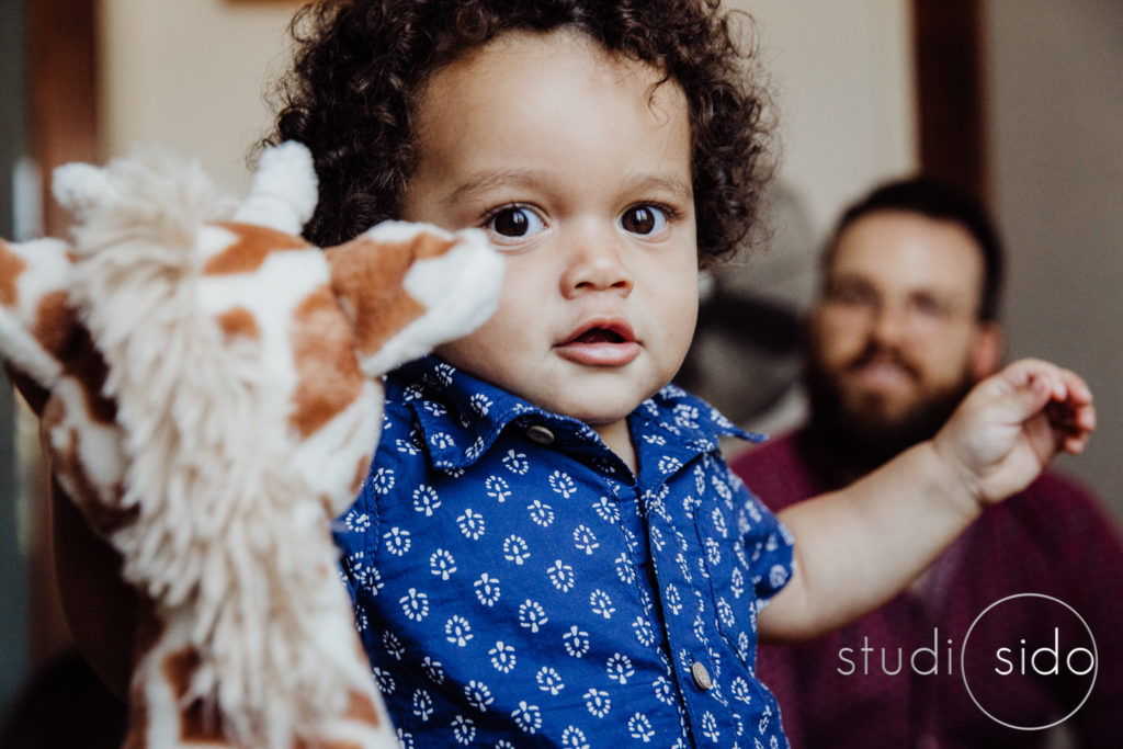 A boy holds his toy giraffe.