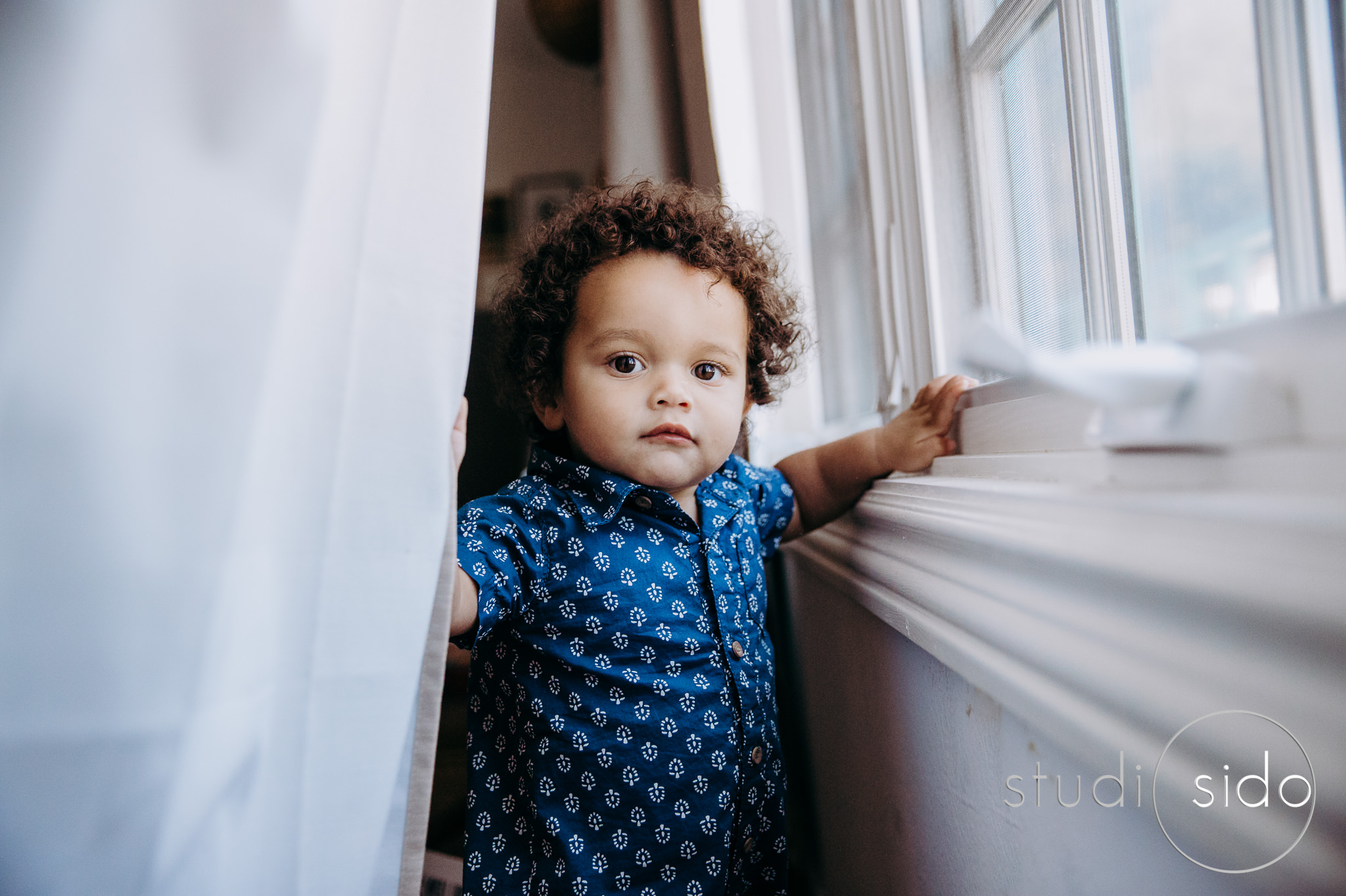 A boy plays with the curtains in West Hollywood, CA.