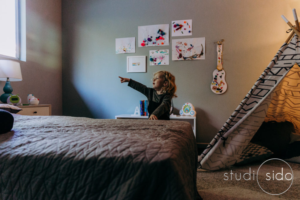 Boy points at window, in home session in Mount Washington, Los Angeles, CA