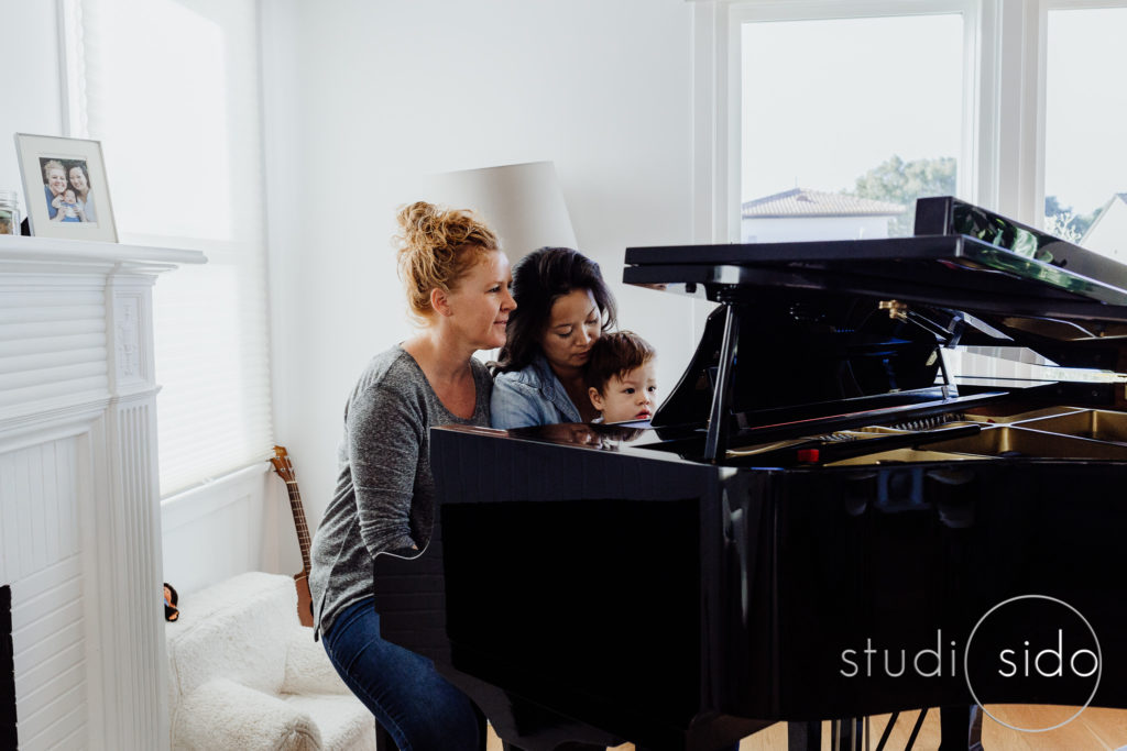 Family plays piano in their home in Los Angeles, CA