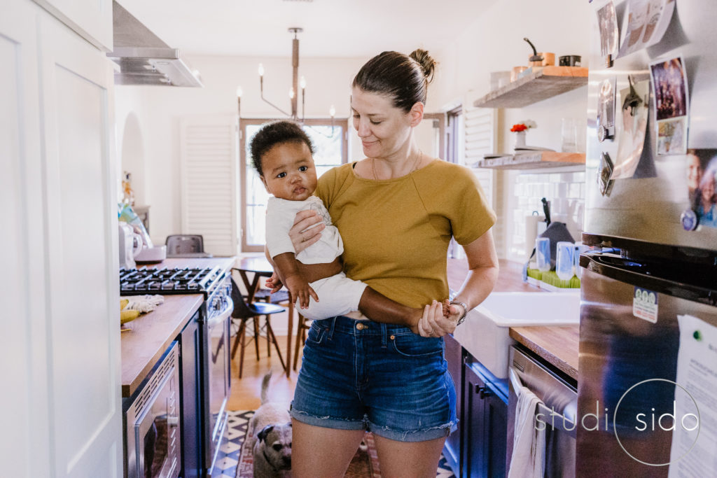 Mom carries son in the kitchen of their home in Silver Lake, Los Angeles, CA