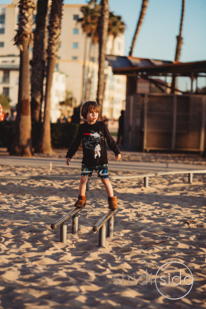 Child balancing on beams on beach