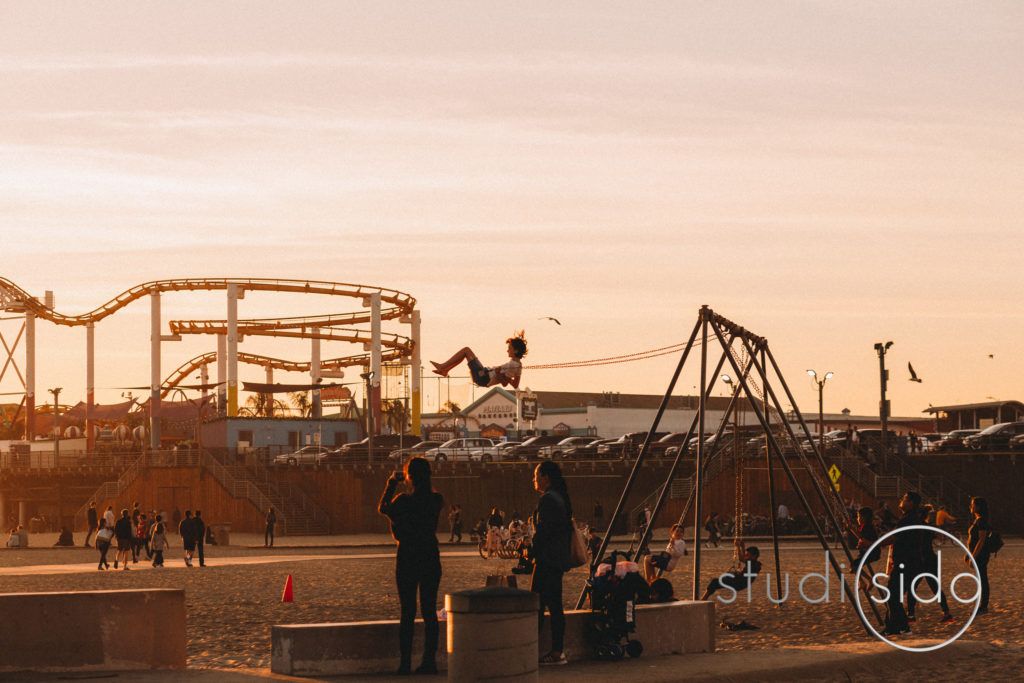 Child swinging on beach at dusk