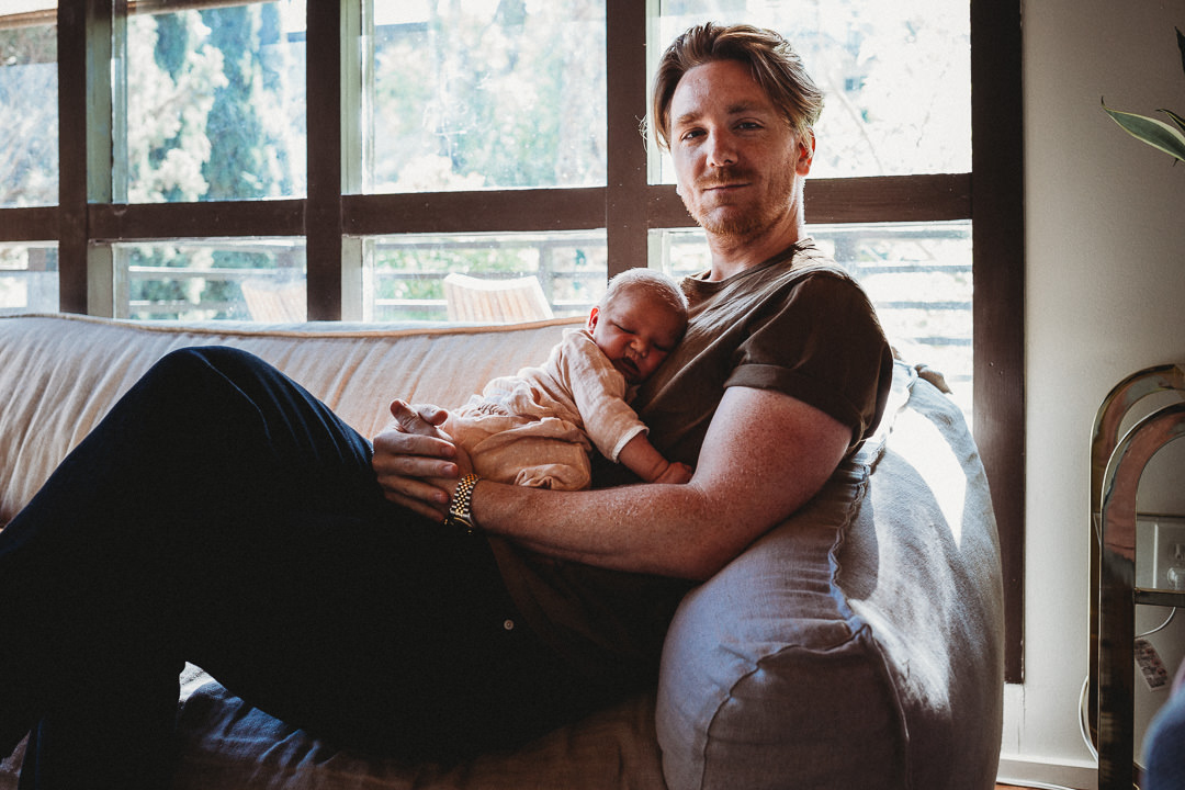 Dad Holding Newborn Baby on Chest on Couch