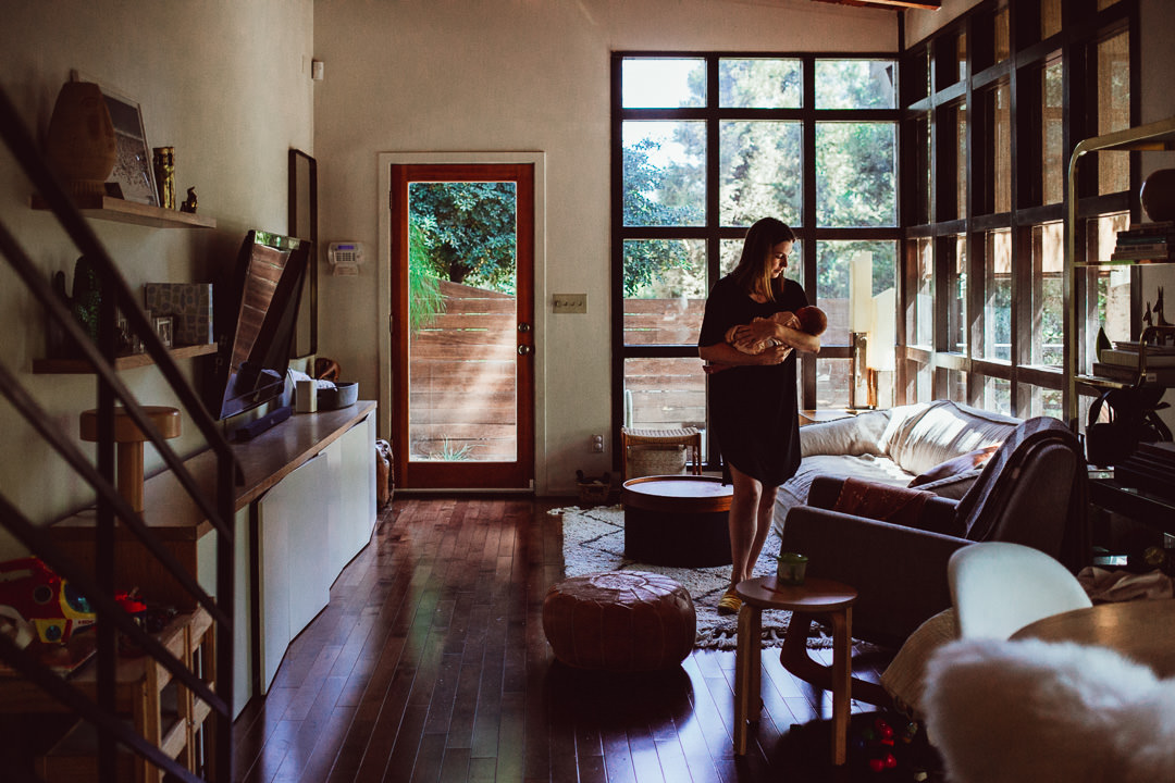 Mom Rocking Newborn Baby While Walking Around Living Room