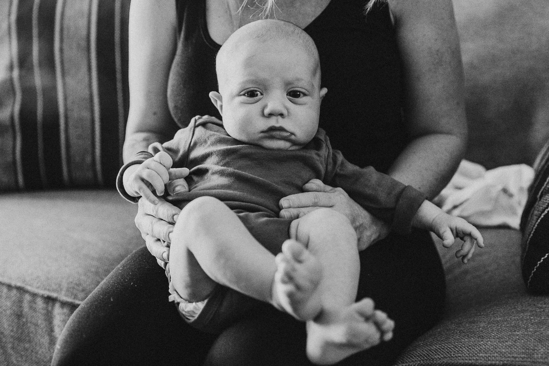 Black and white photograph of baby boy in his mom's lap, Los Angeles, CA