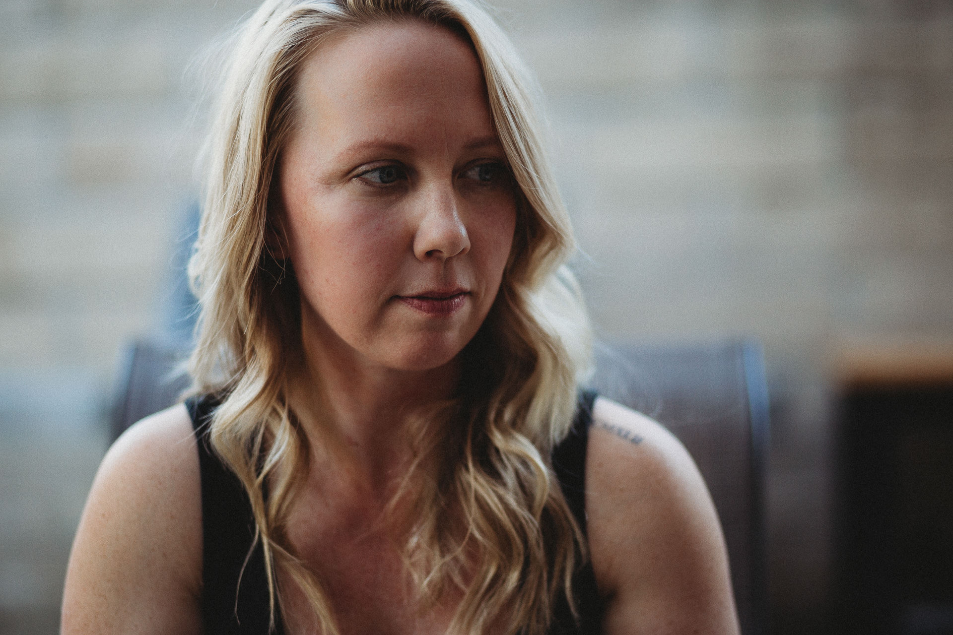 A woman with wavy blonde hair looking sideways