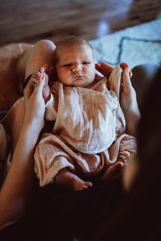 Newborn on mom's lap in their home in Mount Washington, Los Angeles, CA