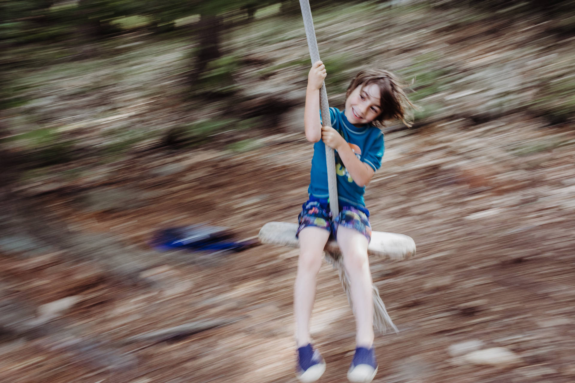 Panning shot of a boy on a swing