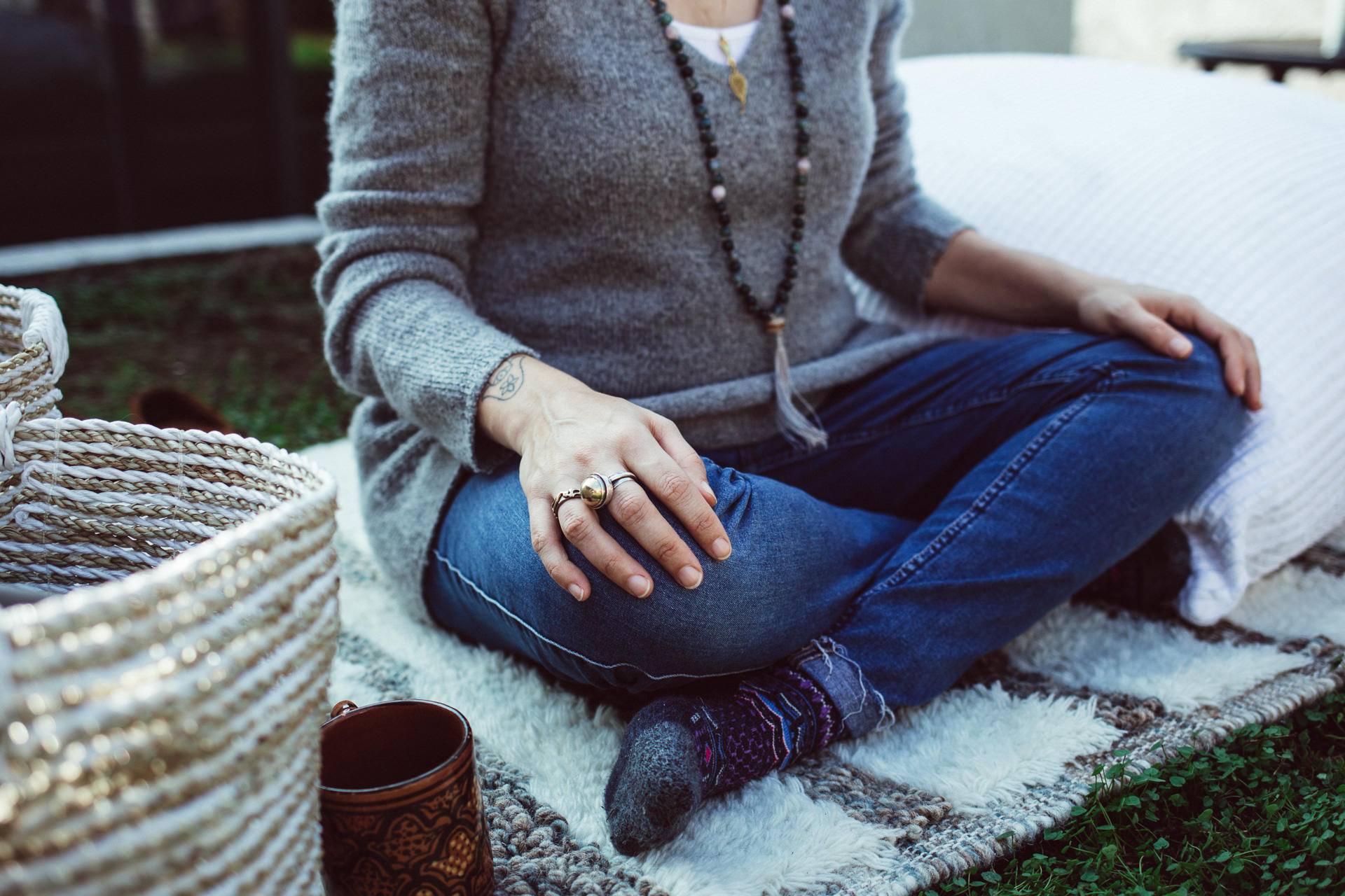 Woman in Blue Jeans Sitting Cross Legged Outside on Blanket