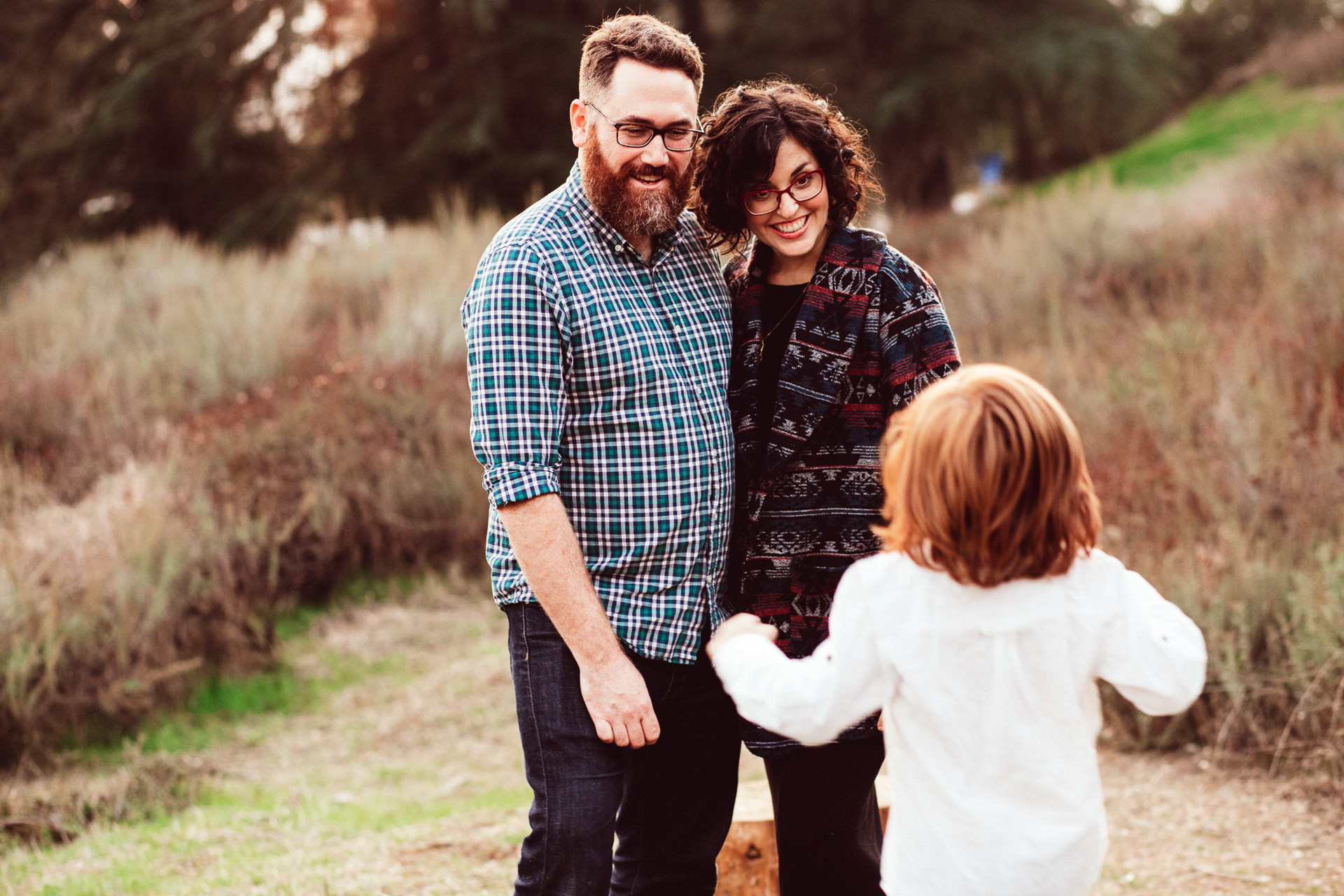 Young Child Excitedly Tells Parents Story Outside in Grass