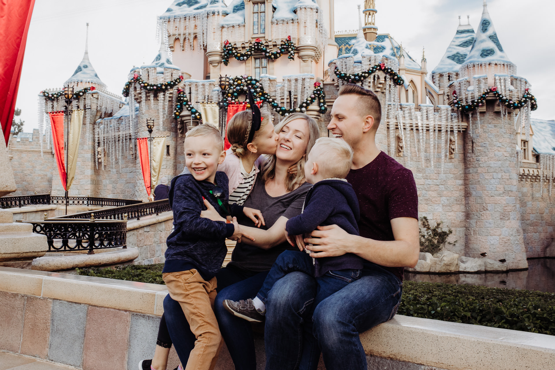 Cuddles and kisses for mama in front of the Disneyland Castle