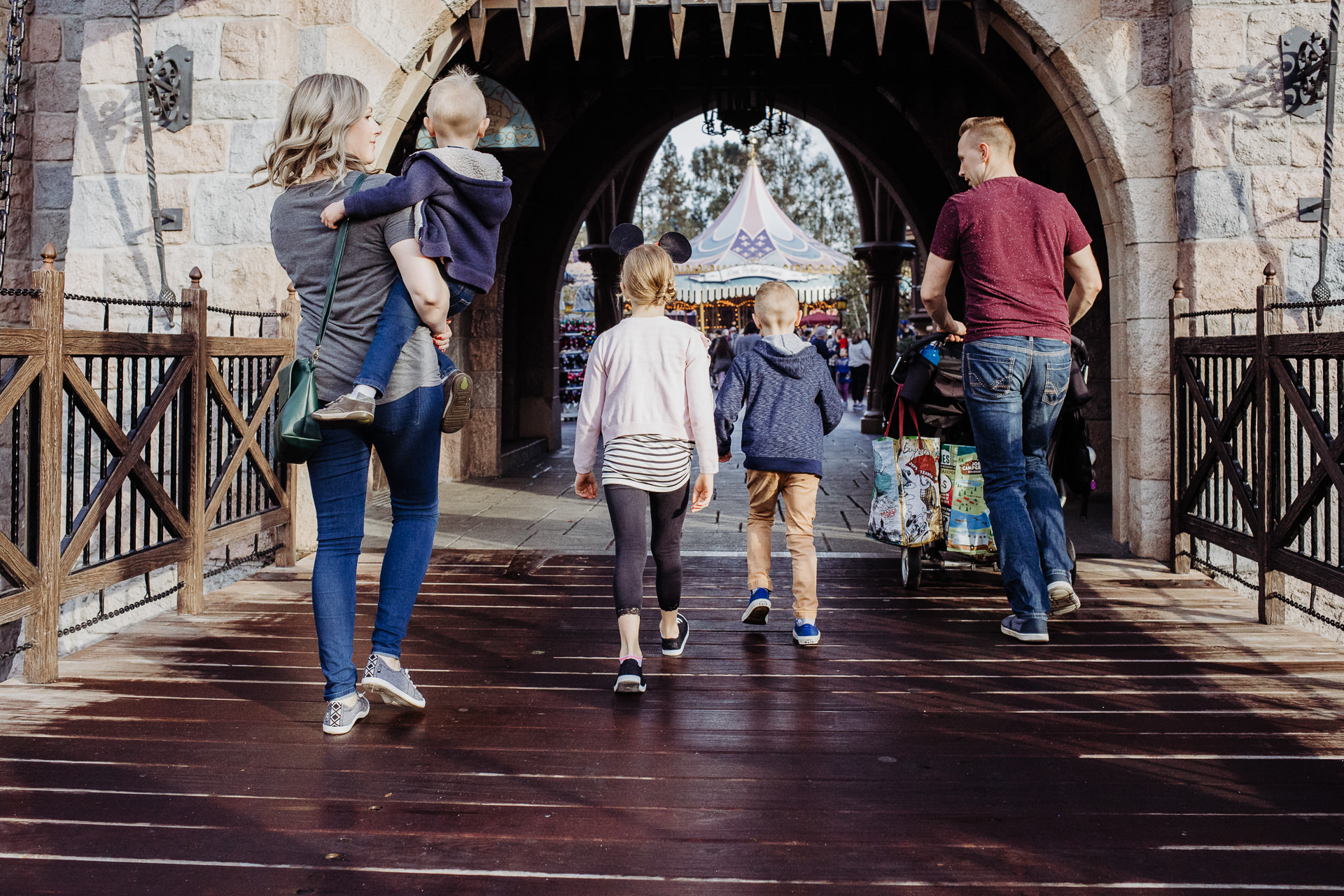 A family of five walk over the bridge to the Disneyland Castle