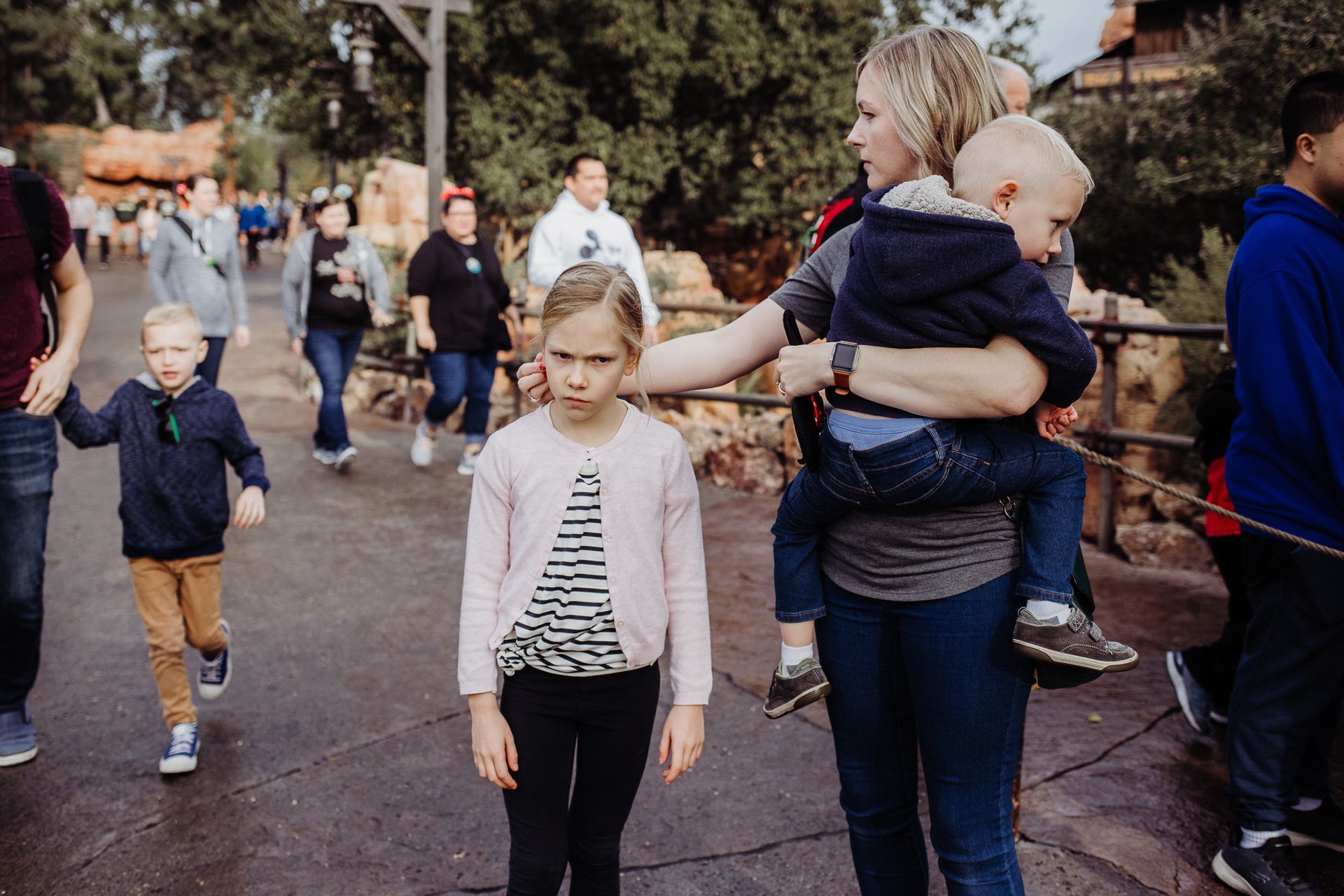 Mom holds her son while touching her daughter's hair at Disneyland, Anaheim, CA