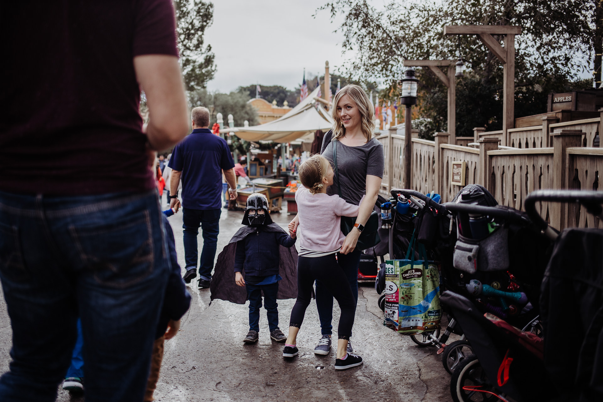 A mom holds her little son's hand who is dressed as Darth Vader at Disneyland