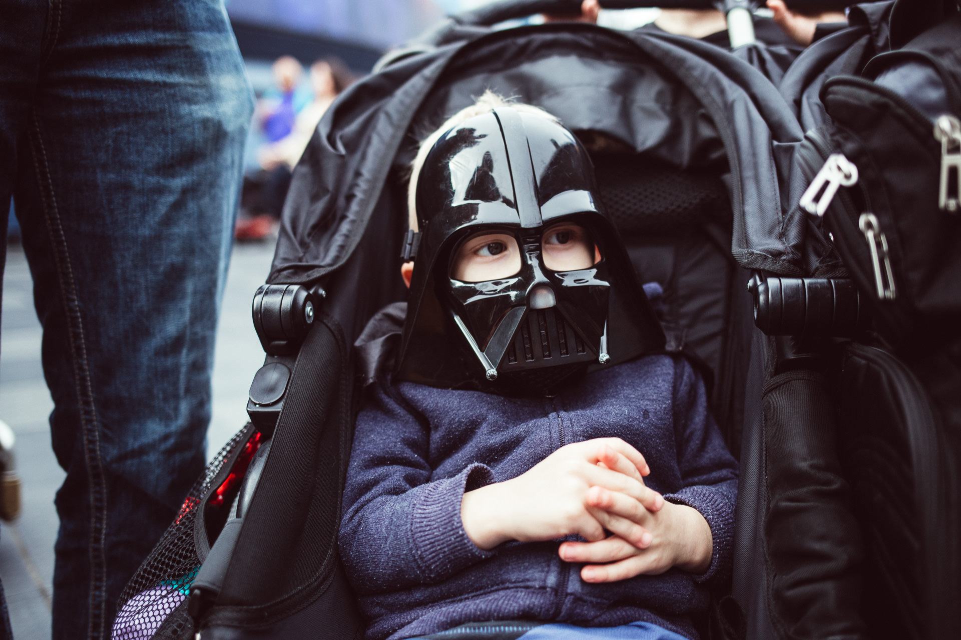 A boy wears a darth vader mask while sitting in his stroller at Disneyland, Anaheim, CA