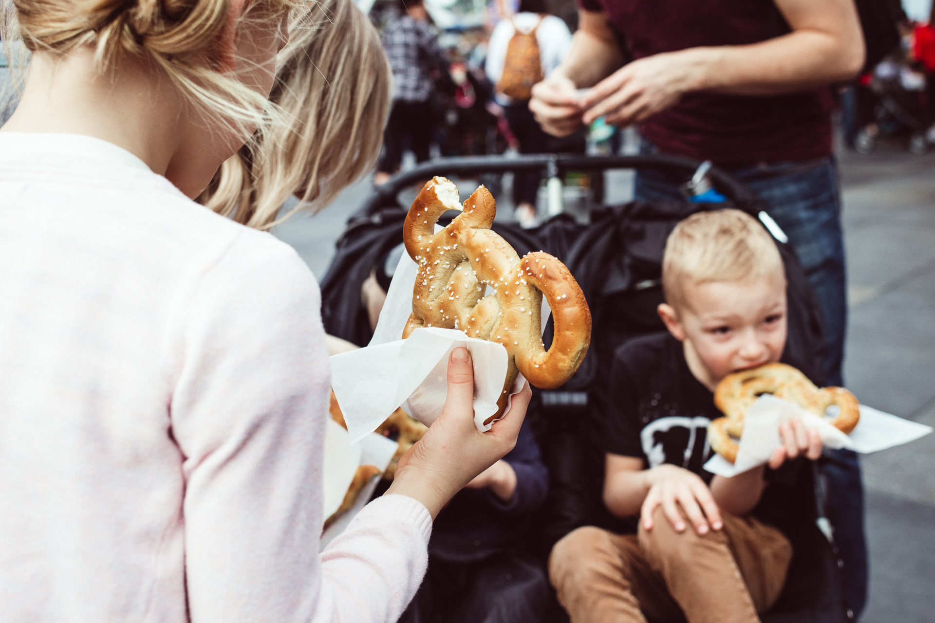 Kids eat Mickey Mouse shaped pretzels at Disneyland