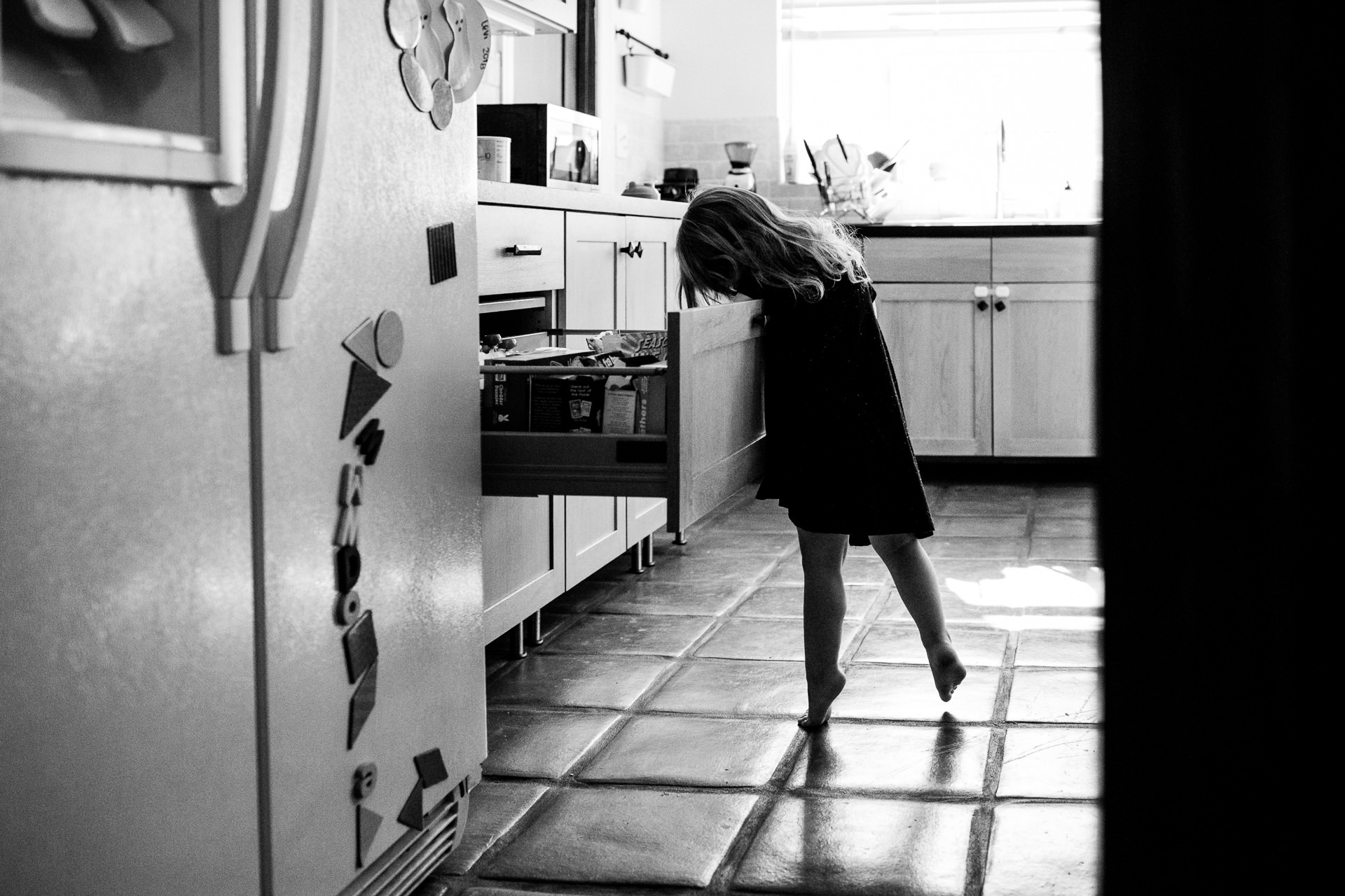 Girl on her tiptoes in her kitchen in Los Feliz, Los Angeles, CA