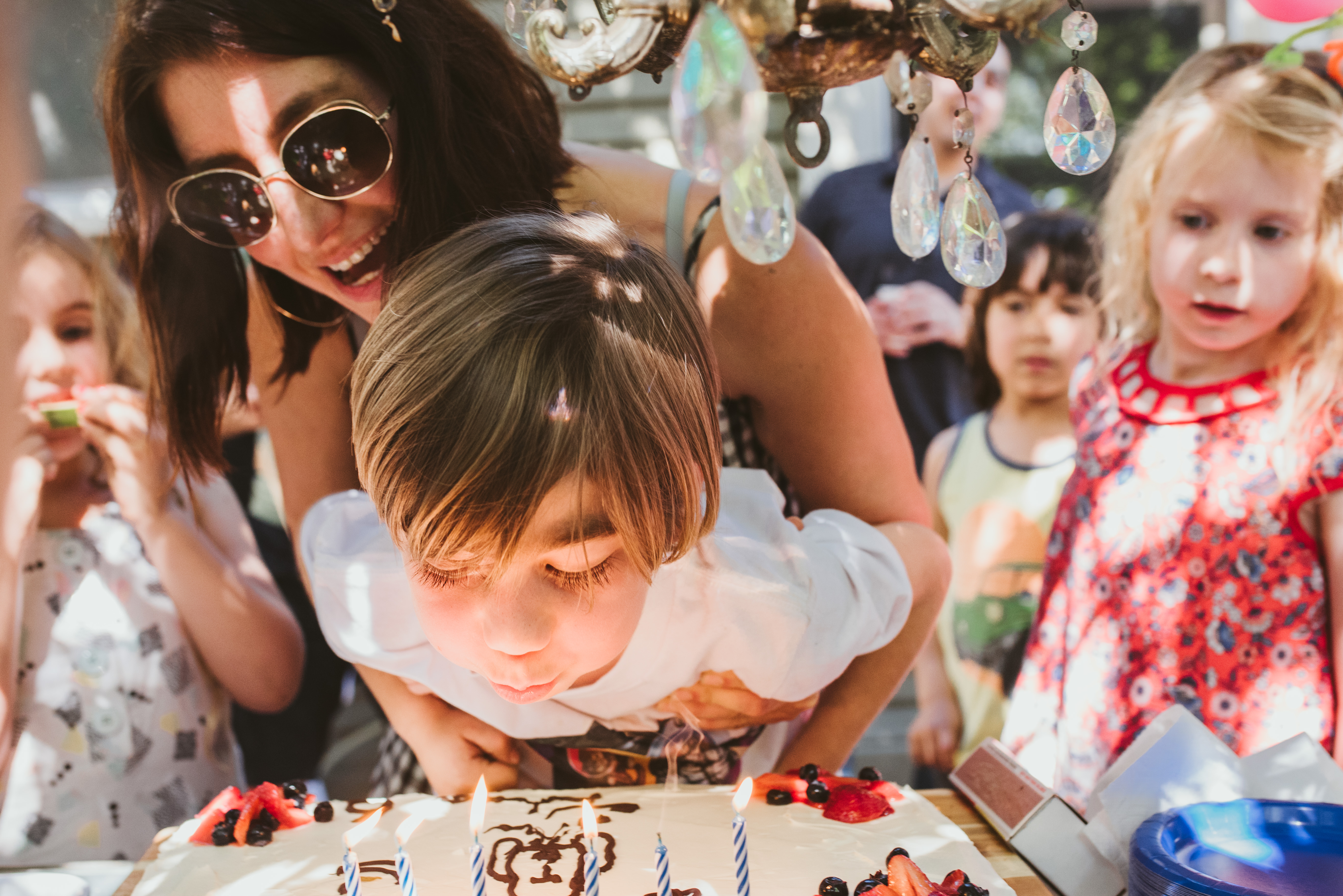 Young Boy Blows Out Birthday Candles at Celebration