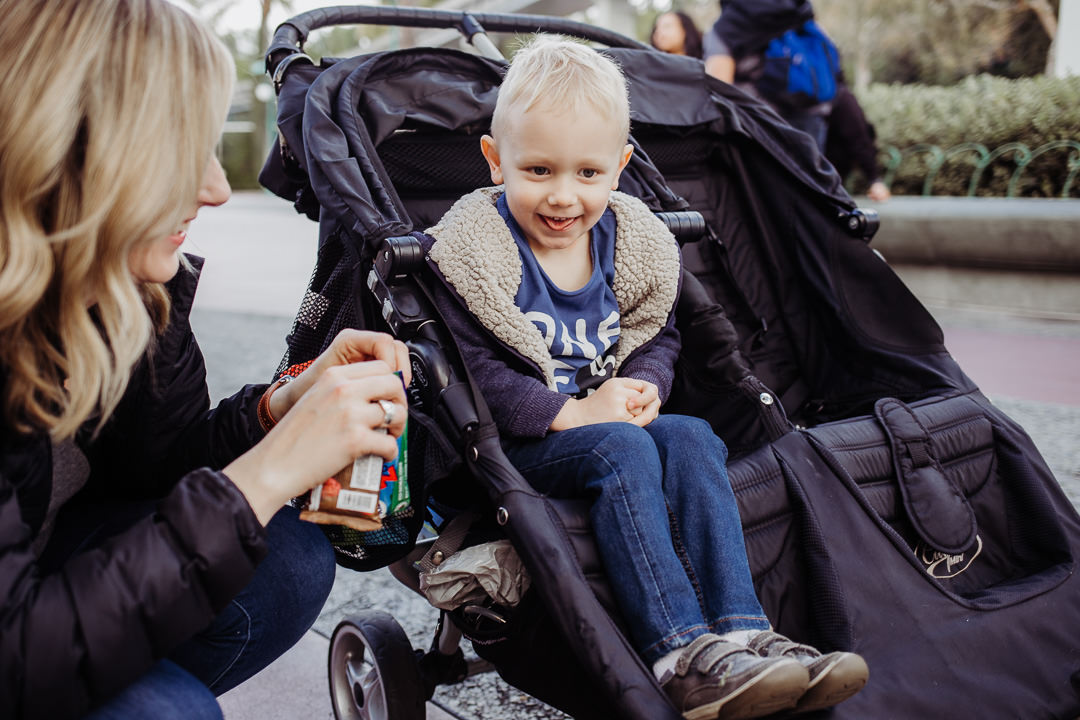 A little boy smiles at his mom in Disneyland