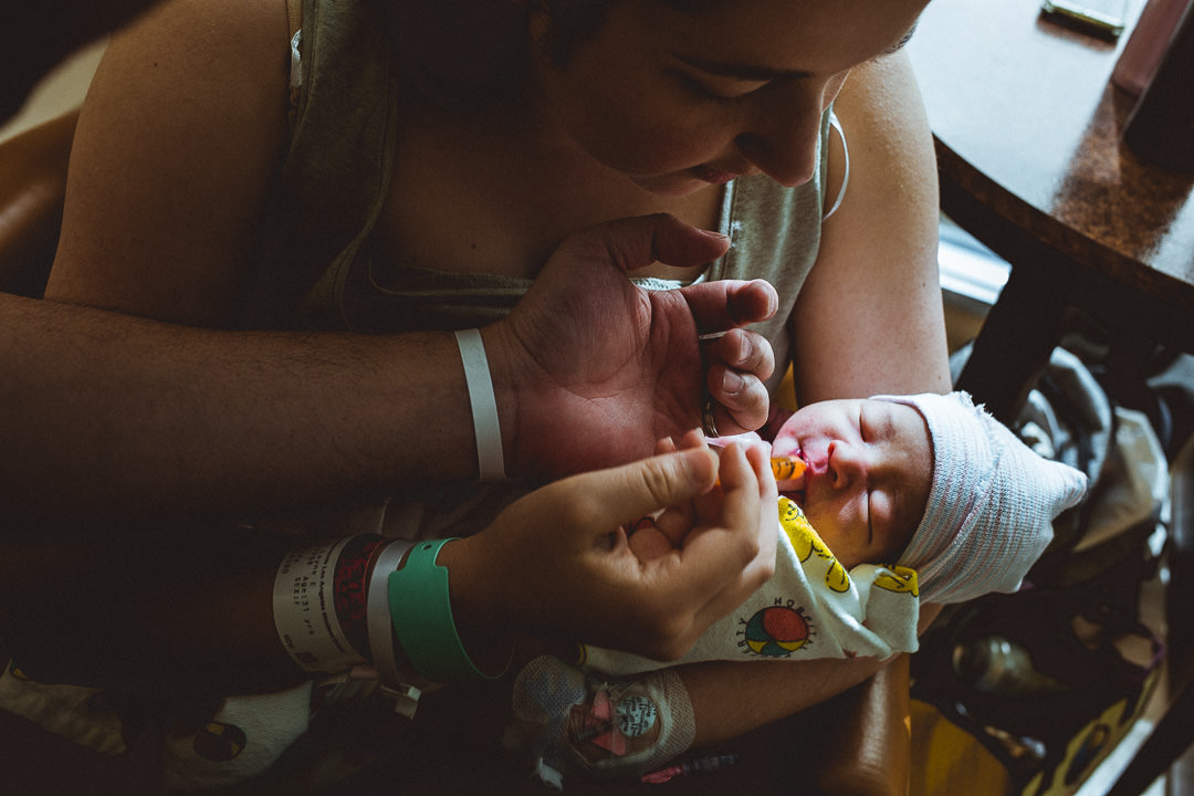 Newborn Baby In Hospital Being Fed by Parents