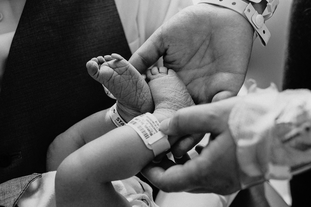 Parent Holding Newborn Baby Feet Black and White Photo