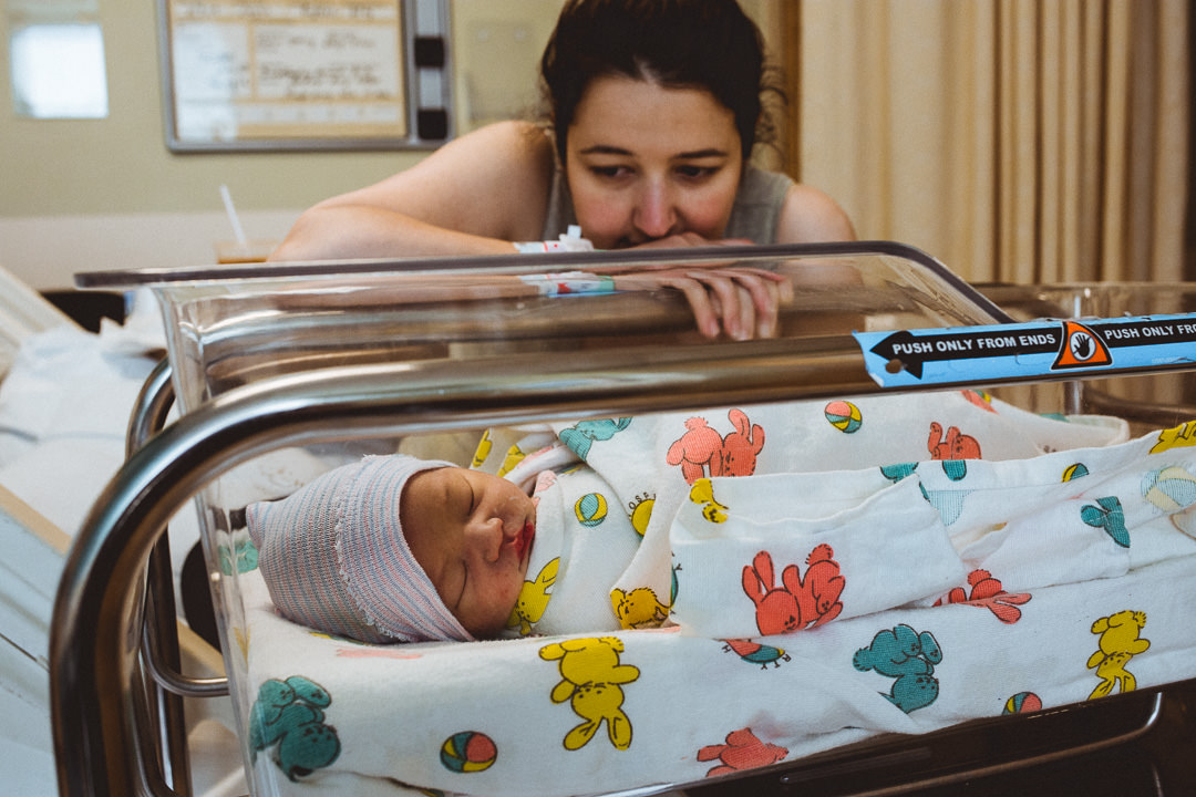 Mom Looking At Baby in Hospital Bassinet