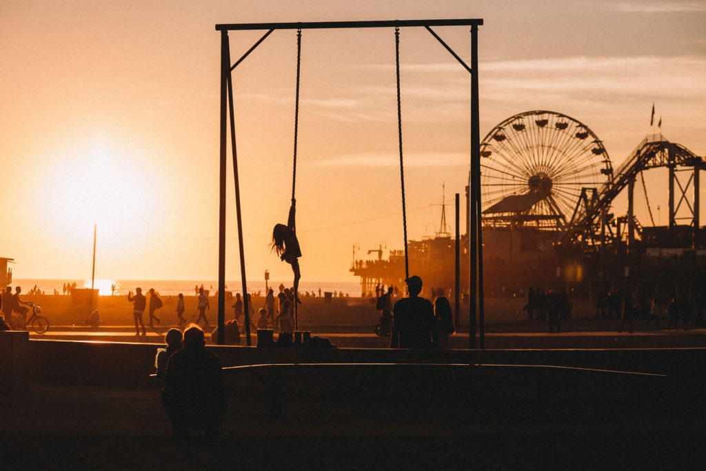 Girl climbs rope at the beach by Santa Monica Pier