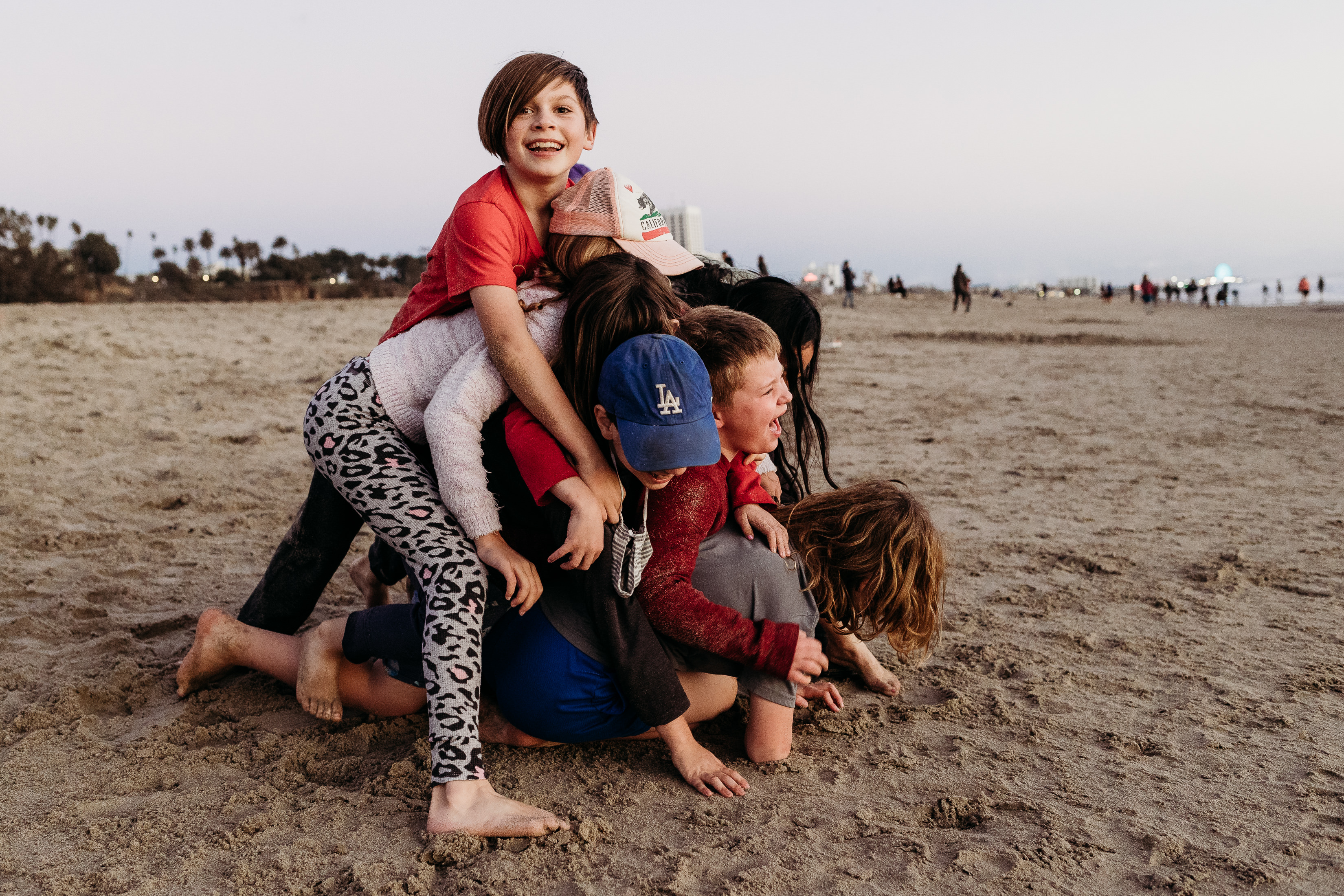 A pile of kids playing in the sand on Santa Monica Beach