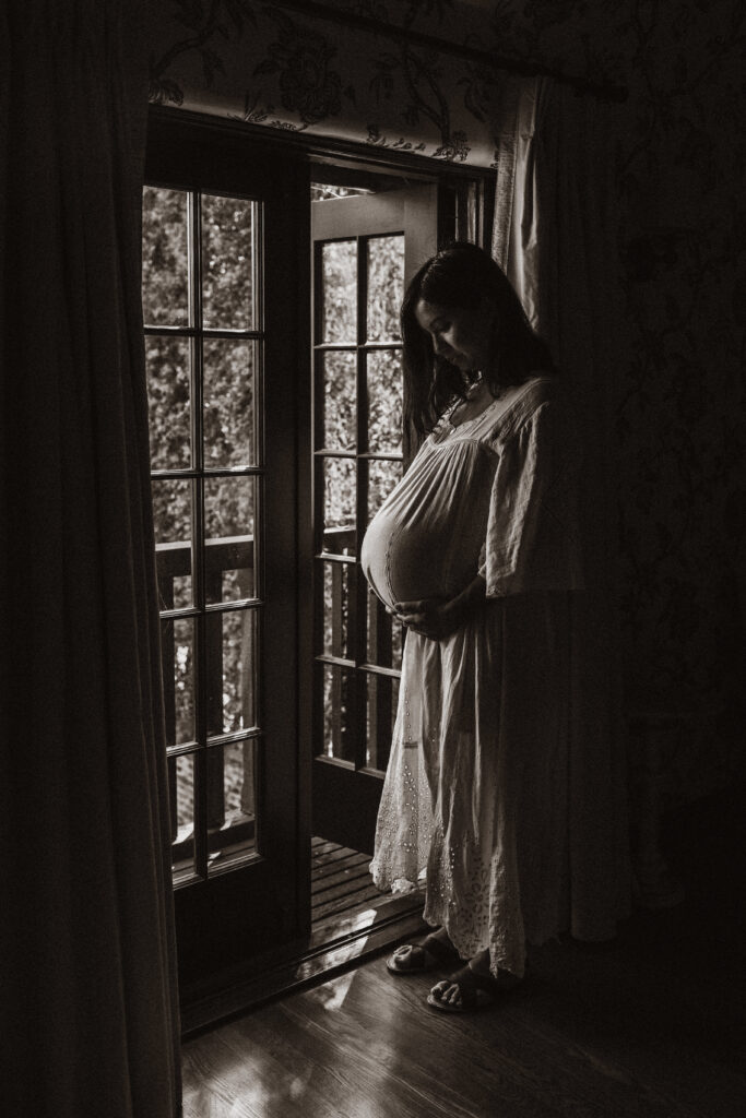 A pregnant woman stands in the doorway