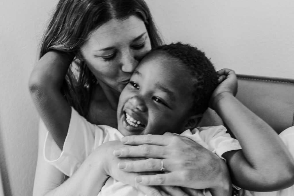 Mother cuddles her son black and white photo