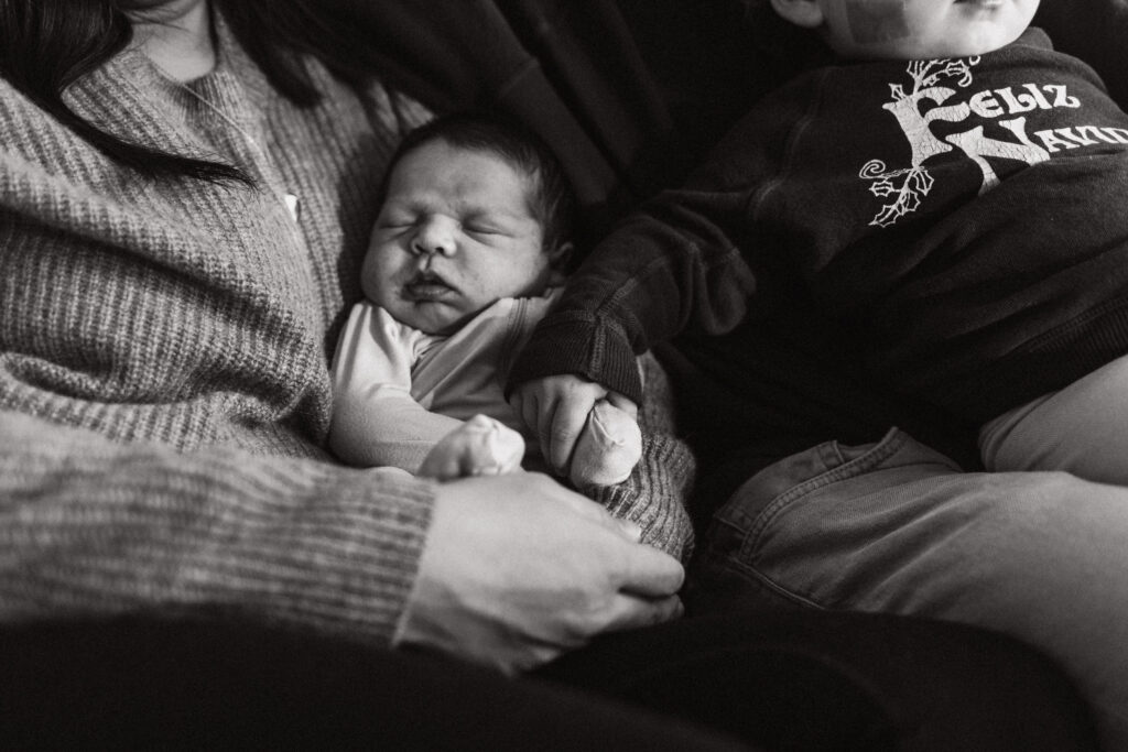 Baby Snuggled Into Parent's Arms Black and White Photo