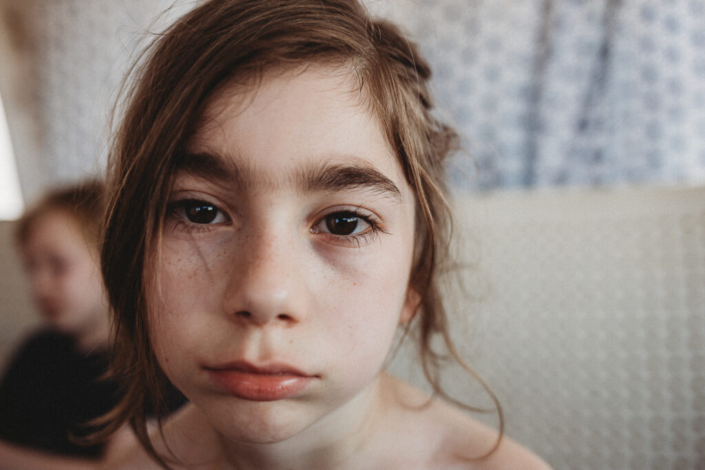 Young Child Looking Solemn At Camera